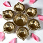 7-inch decorative brass mini urli bowl with 6 diyas, surrounded by rose petals, perfect for festive decor.