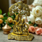 Antique brass Radha Krishna idol under beautifully carved tree for spiritual home decor.