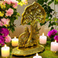 Handcrafted Brass Radha Krishna Idol under tree with antique finish, adorned with flowers and candles for home decor.